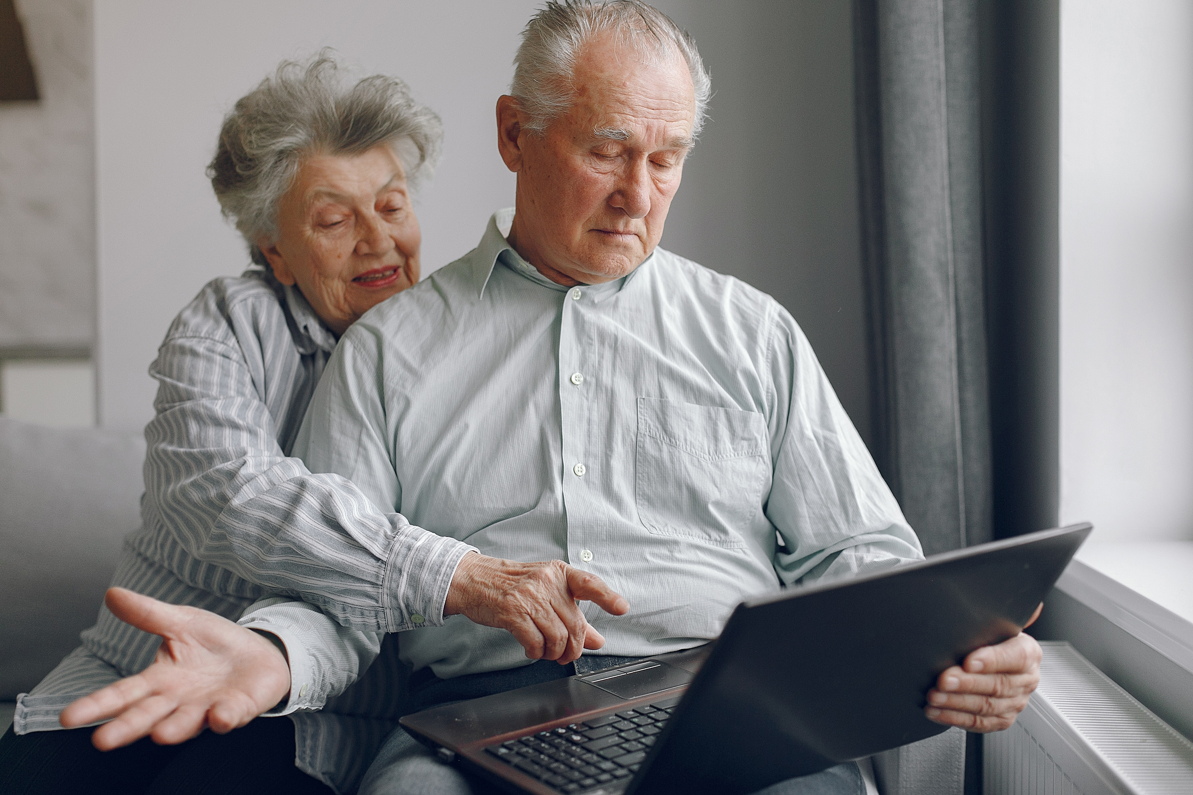 elegant-old-couple-sitting-home-using-laptop